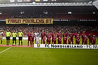FCN-fans med banneret "Farum pokalens by" bag de to hold og dommerne