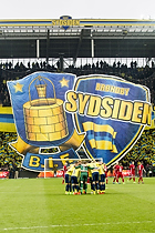 Spillerne i rundkreds foran Sydsiden tifo